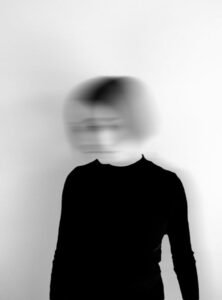 Black and white silhouette of a woman with a blurred face, creating an artistic and mysterious effect.